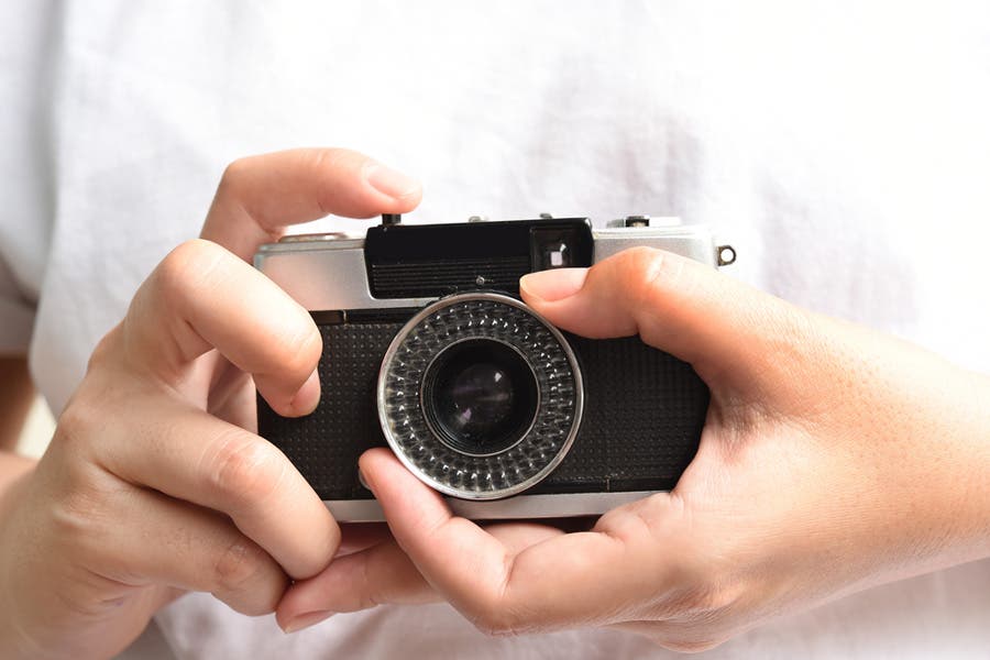 woman holding a film camera for street photography