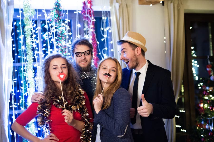 group of friends holding Christmas photo booth props