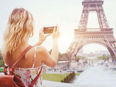 Blonde woman using iPhone X for travel photography