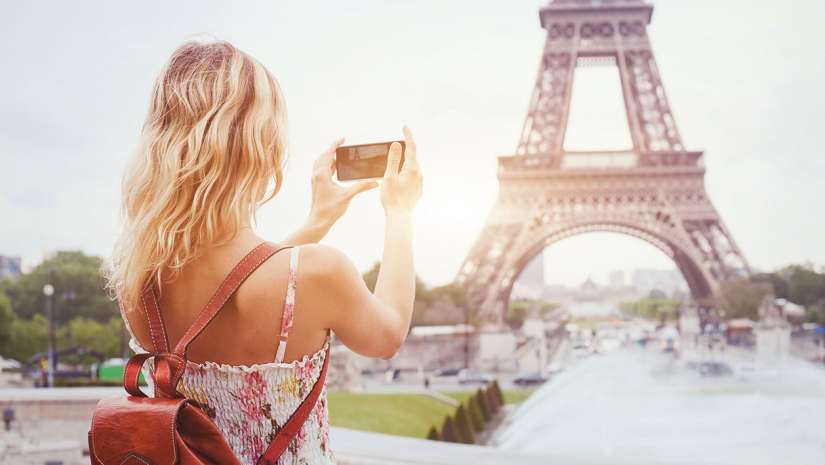 Blonde woman using iPhone X for travel photography