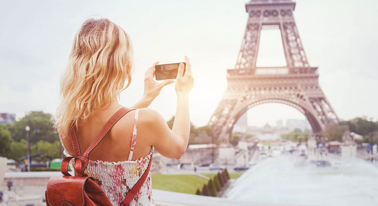 Blonde woman using iPhone X for travel photography