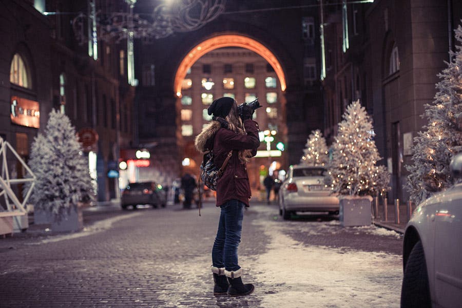 woman shooting street photos in the snow with a professional camera