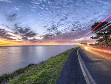 Time Lapse shot of water, clouds, and car lights