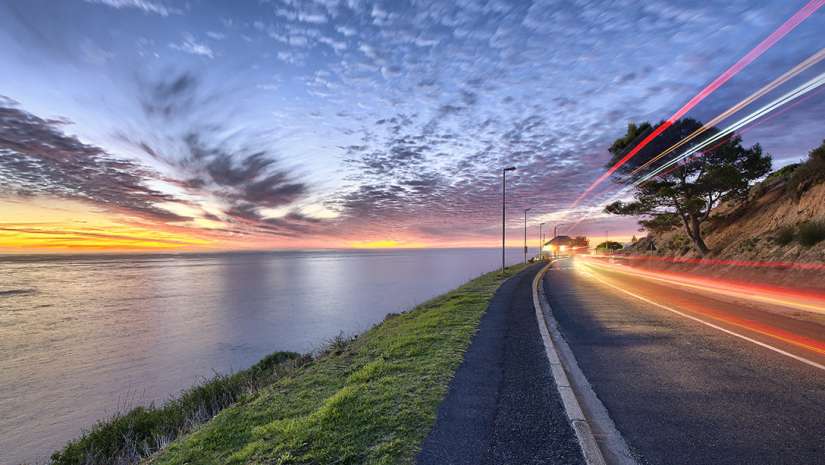Time Lapse shot of water, clouds, and car lights