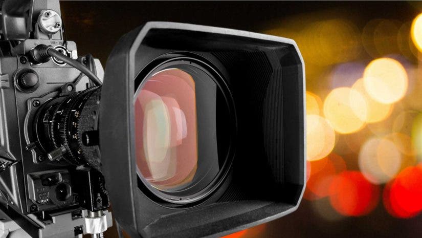 Cinema camera lens up close with bokeh lights in background