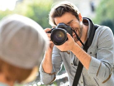 Photographer taking picture of trendy model in park