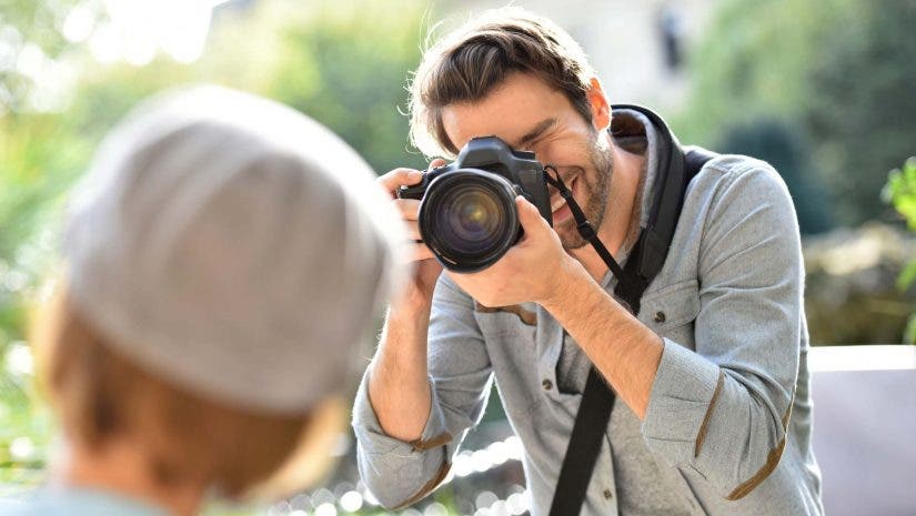 Photographer taking picture of trendy model in park