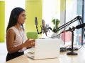 woman doing a podcast in front of a mic and laptop