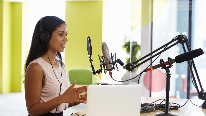 woman doing a podcast in front of a mic and laptop