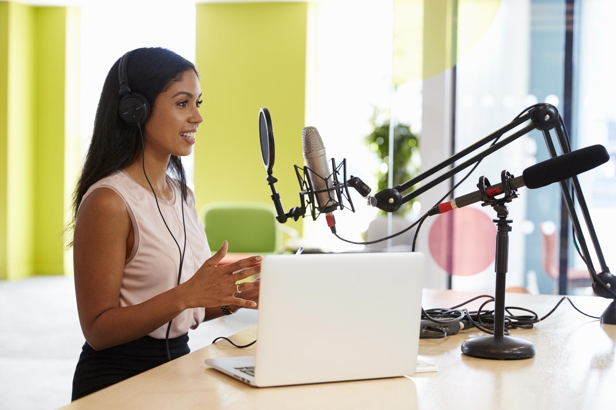 woman doing a podcast in front of a mic and laptop