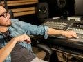 Music producer behind recording studio booth