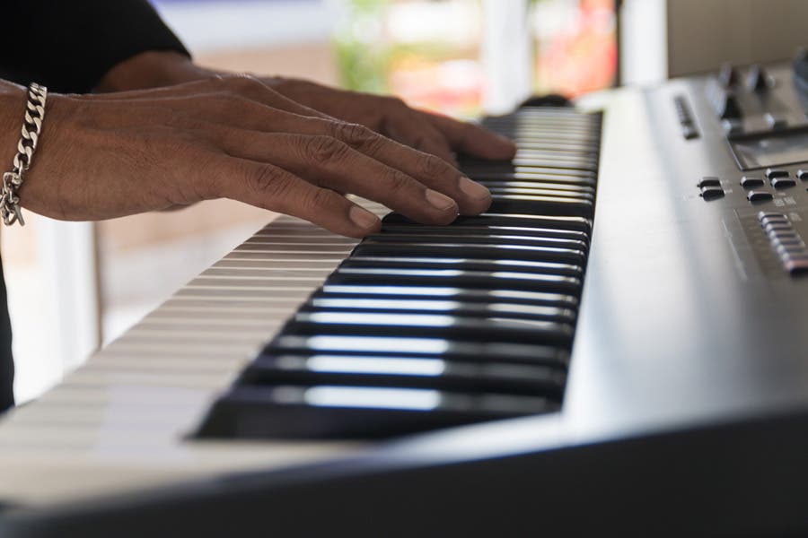 Close-up of a woman’s hands playing a digital piano
