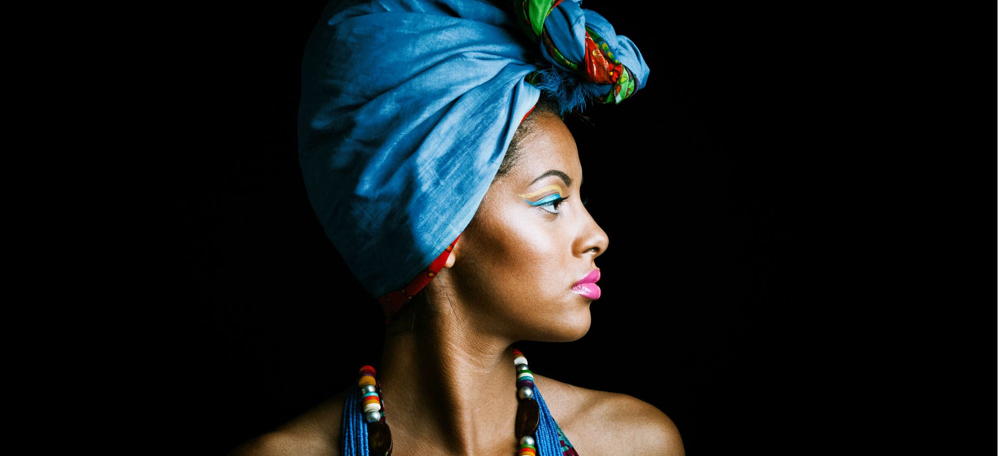 Studio side portrait of african woman in a colorful ensemble