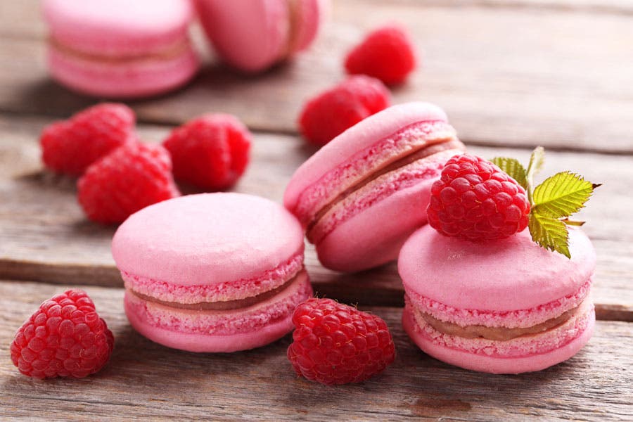 Artistic shot of berries and pink macarons