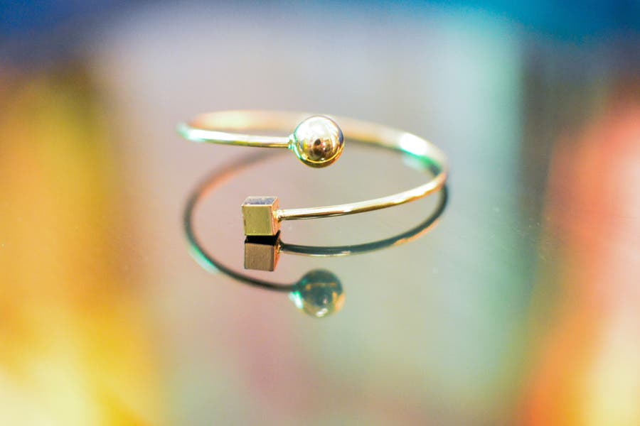 gold bangle on reflective colored surface