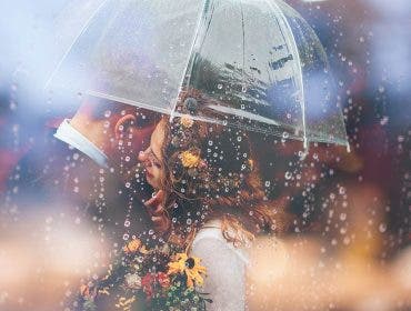 wedding photography styles with bride and groom under umbrella in rain
