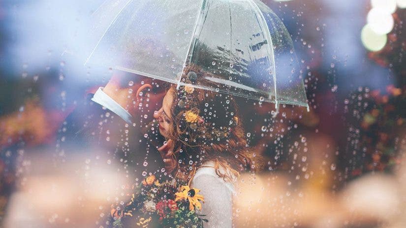 wedding photography styles with bride and groom under umbrella in rain