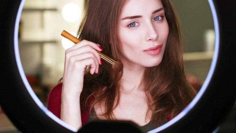 beauty guru doing makeup video in front of ring lights