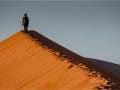 landscape photographer walking on sand dune
