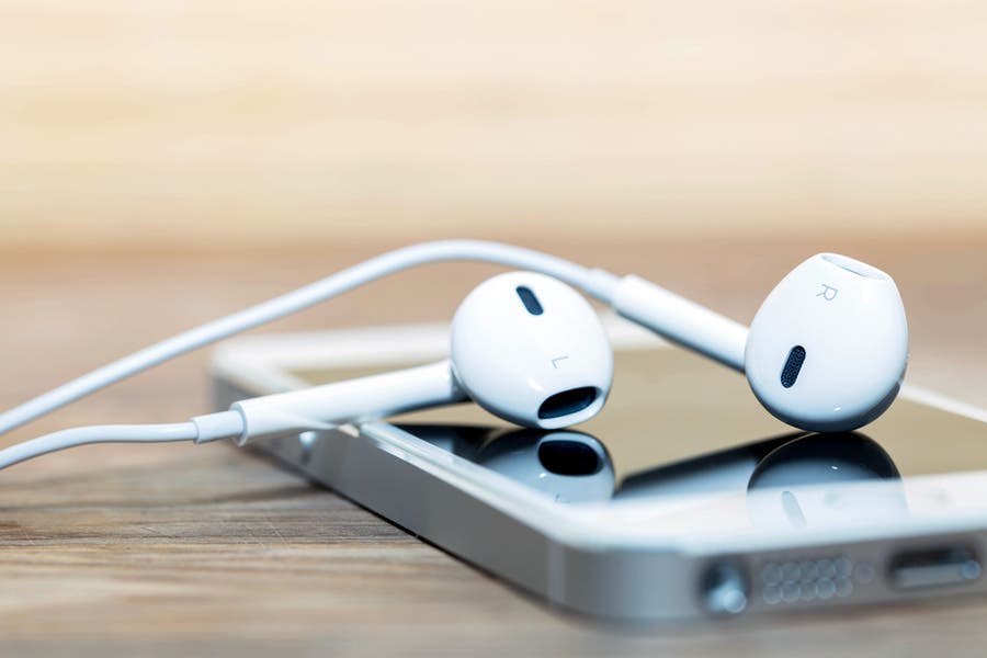 narrow depth of field shot of apple earphones on top of iphone