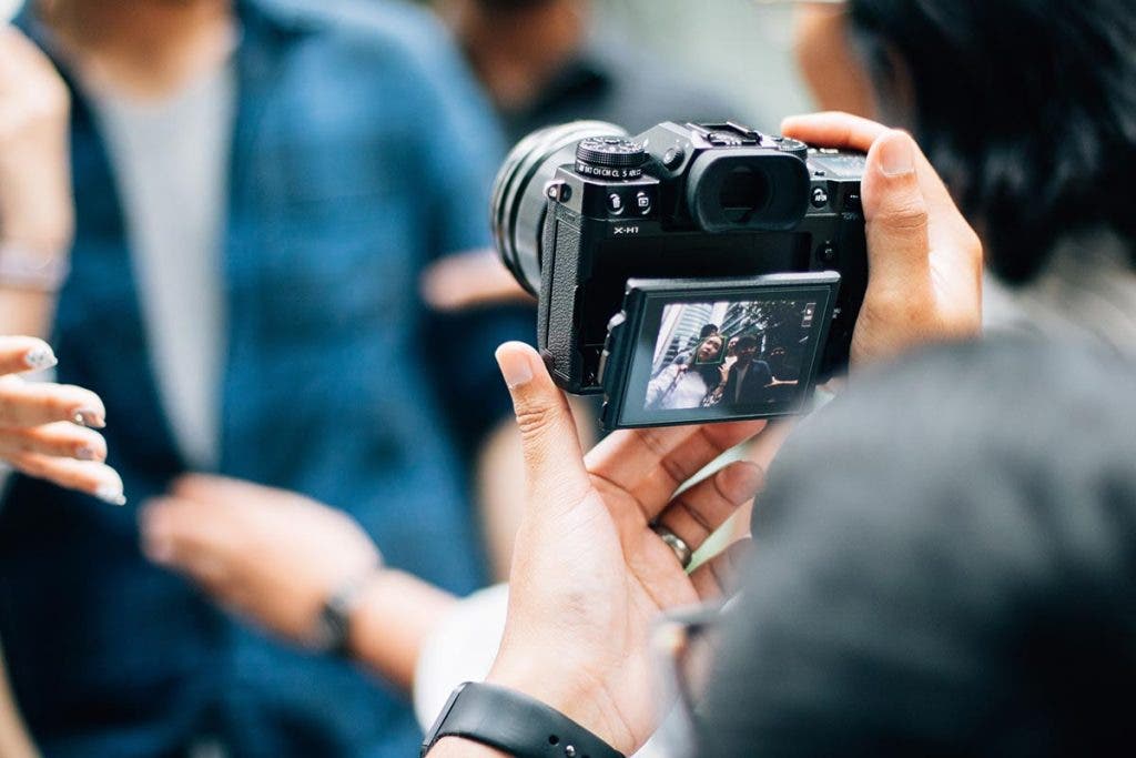 photographer holding camera with flip out touchscreen