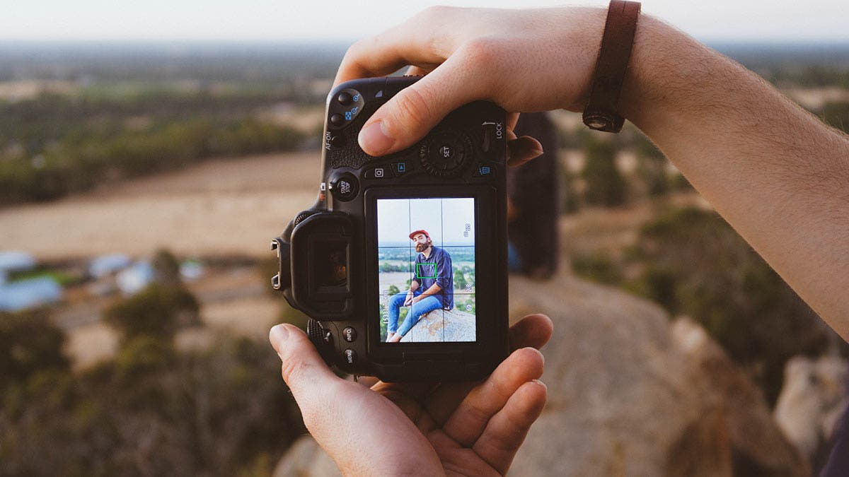 photographer holding camera taking photo of man