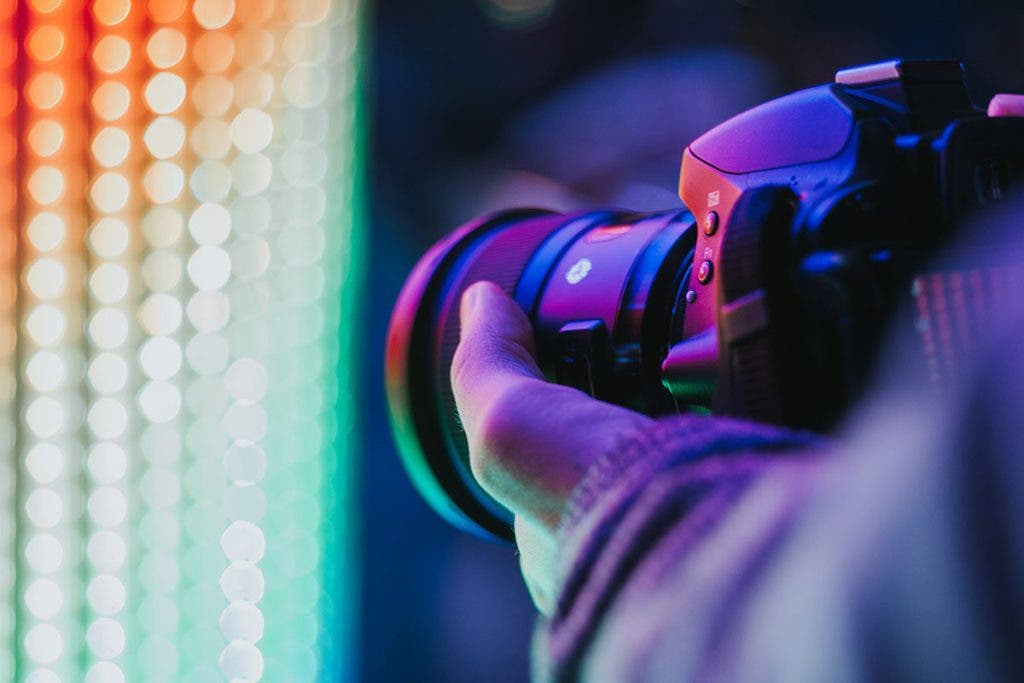 photographer holding camera taking pictures of led lights