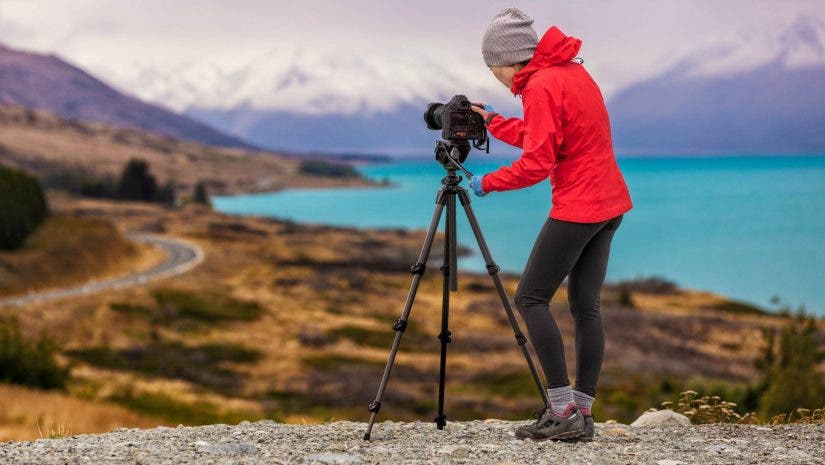 photographer setting up camera on tripod for overlooking shot