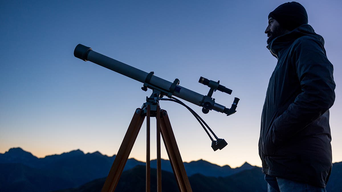 Beginner's Guide to Telescopes a man watches the night sky
