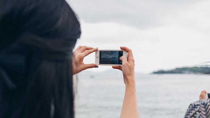 woman taking photo boat