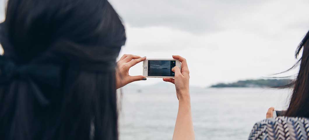 woman taking photo boat
