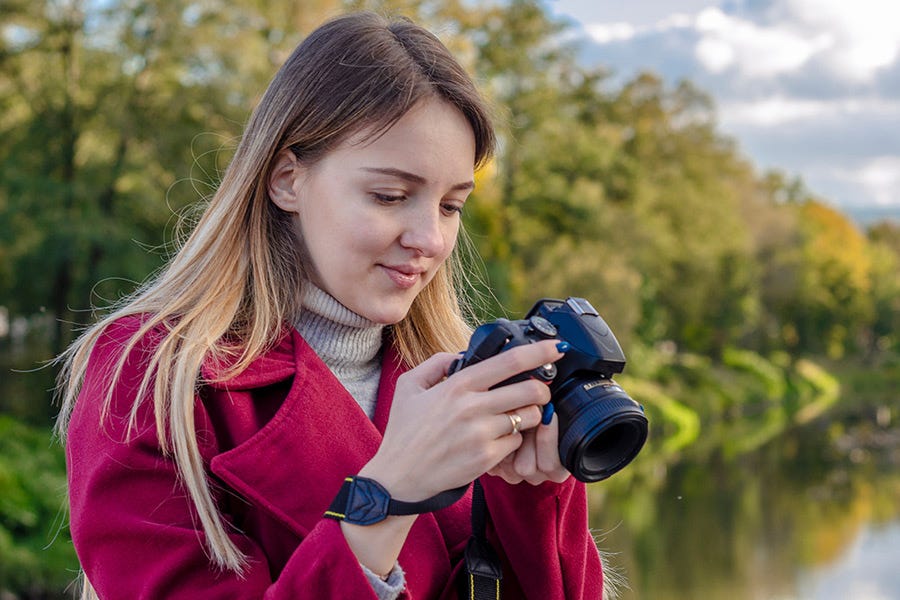 female photographer using a camera with a mounted prime lens