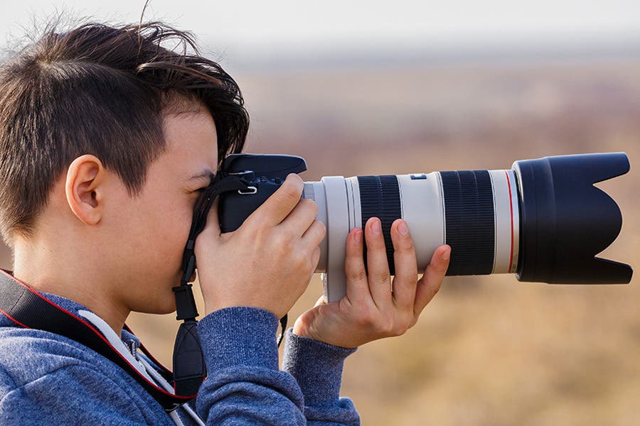 male photographer shooting with a Canon L-series zoom lens