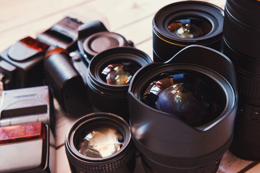 collection of lenses and other camera accessories on a wooden table