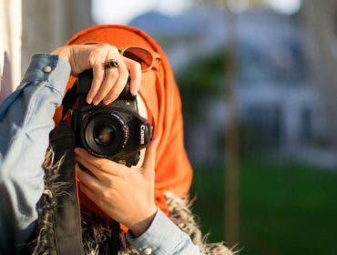 Muslim woman holds a Canon camera