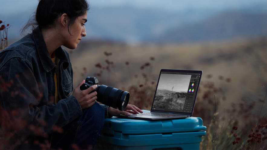 photographer with apple macbook pro with new apple m1 chip