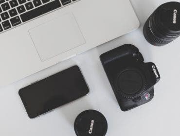macbook laptop and canon camera and lenses on desk branding tips for creative businesses