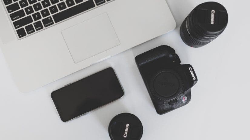 macbook laptop and canon camera and lenses on desk branding tips for creative businesses