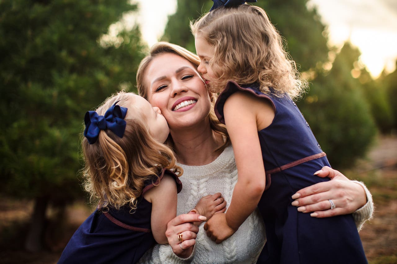 kids photography ideas for creative photos as Mom snuggles with two daughters