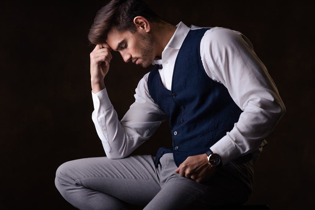 Male model poses in seated position using shapes to keep the viewer in the image
