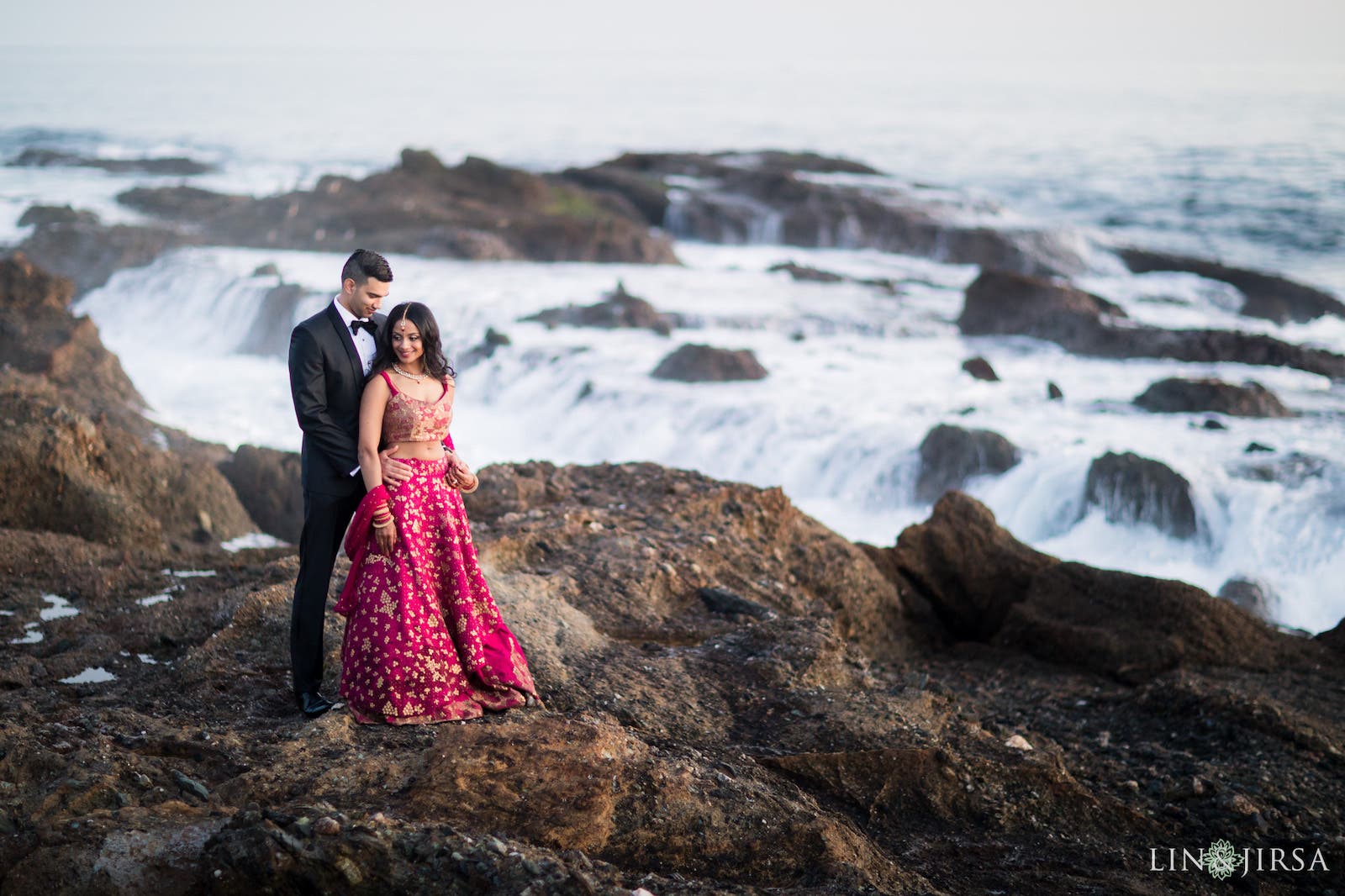 Couple stands in stacked pose on the beach