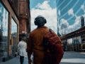 man walking through city with over ear headphones