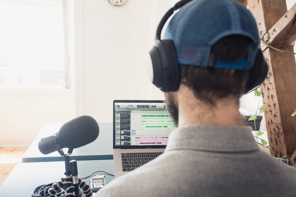 man recording podcast with headphones and microphone