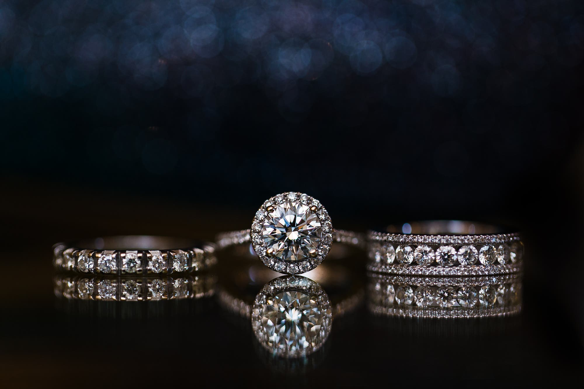 Wedding rings lined up in front of dark backdrop