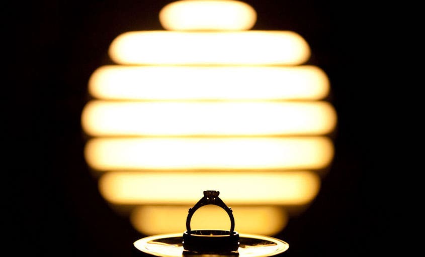 wedding ring outlined as silhouette agains circular light
