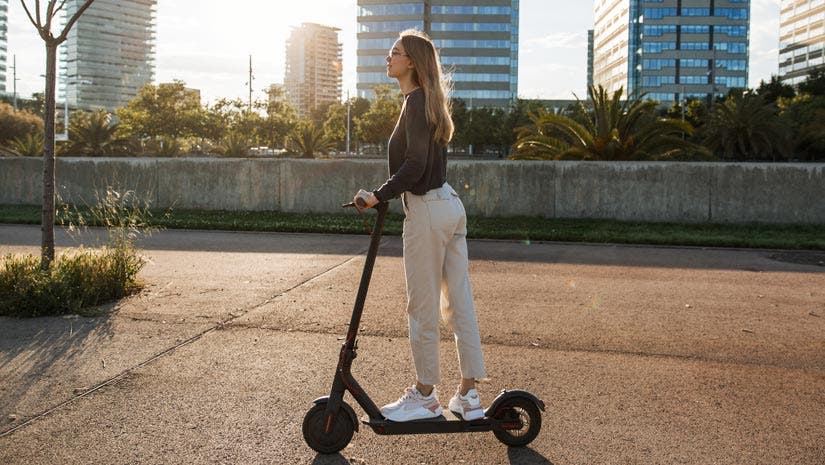 best electric scooters woman commuting on scooter in city