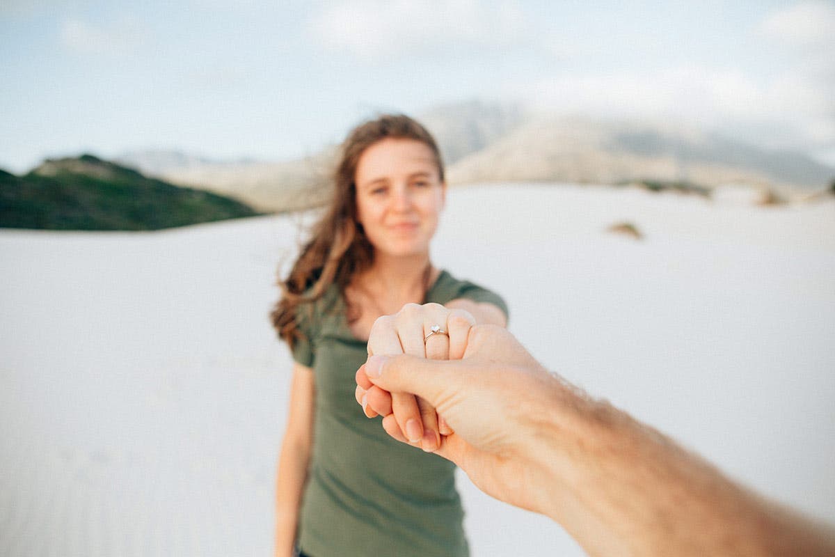 engaged woman holding hands showing off engagement ring