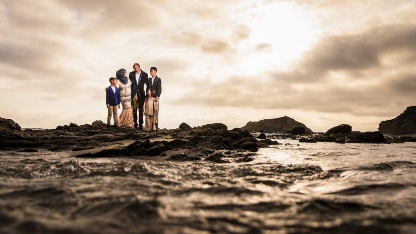 family at beach with water in foreground