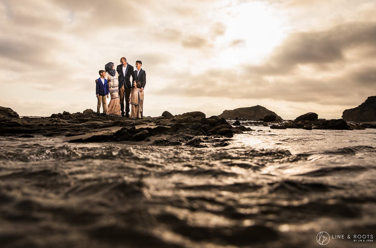 family at beach with water in foreground