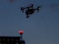 uas night operations drone flying at night over buildings in dark sky